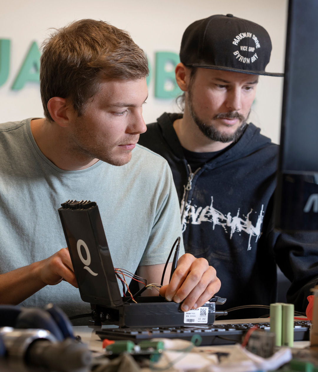 Two men collaborate on a computer, showcasing innovation and teamwork in Gothenburg's work environment.